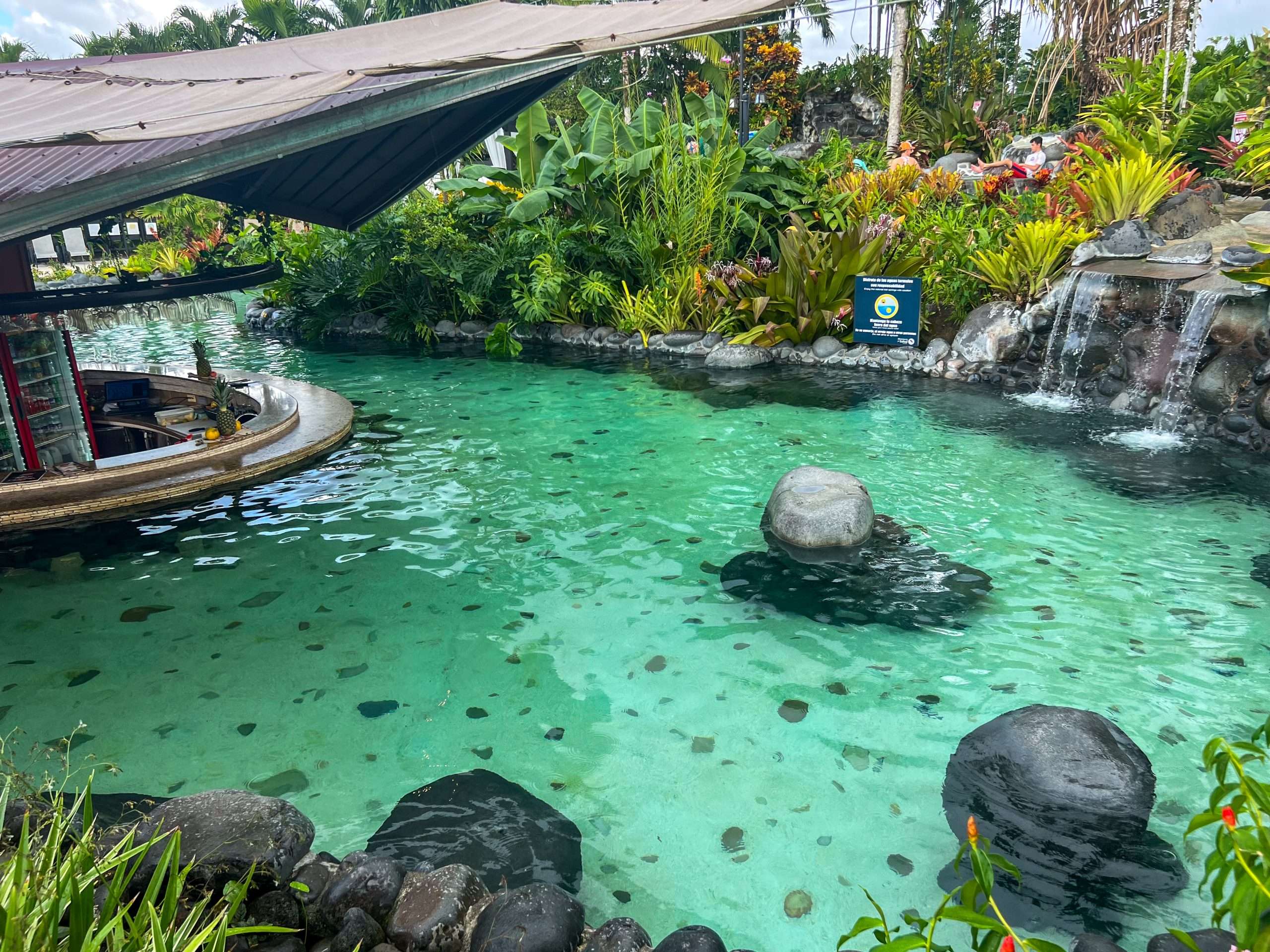 A turquoise pool of water with circular bar to the left