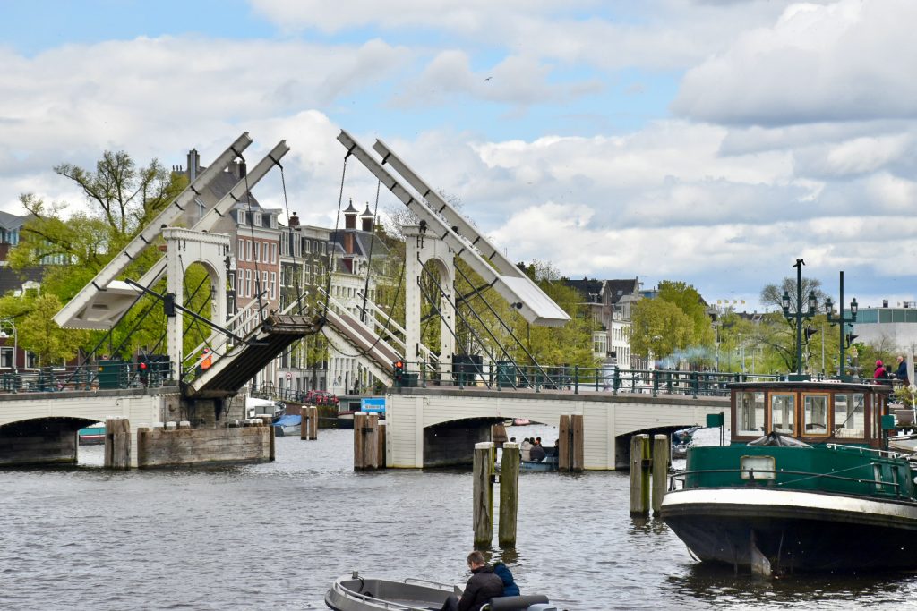 Photo taken on water, what looks like a canal, looking towards an old wooden