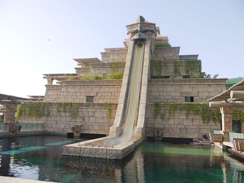 Pyramid shaped structure with water slide on the front down to the pool