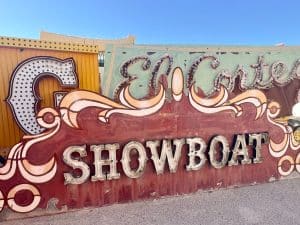 Old fashioned brown neon sign which spells ShowBoat in lightbulbs. Other signs behind with blue sky