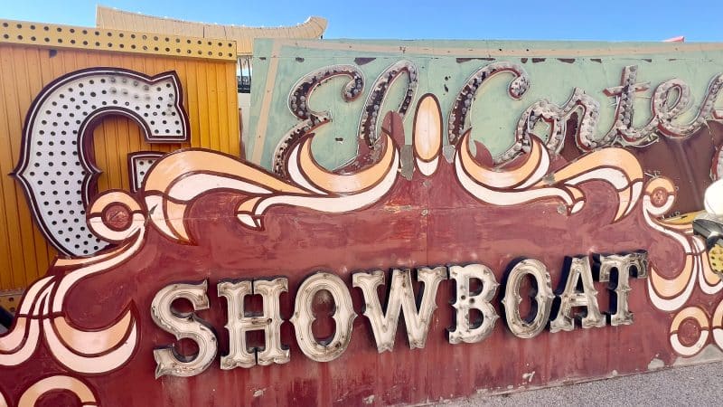 Old fashioned brown neon sign which spells ShowBoat in lightbulbs. Other signs behind with blue sky