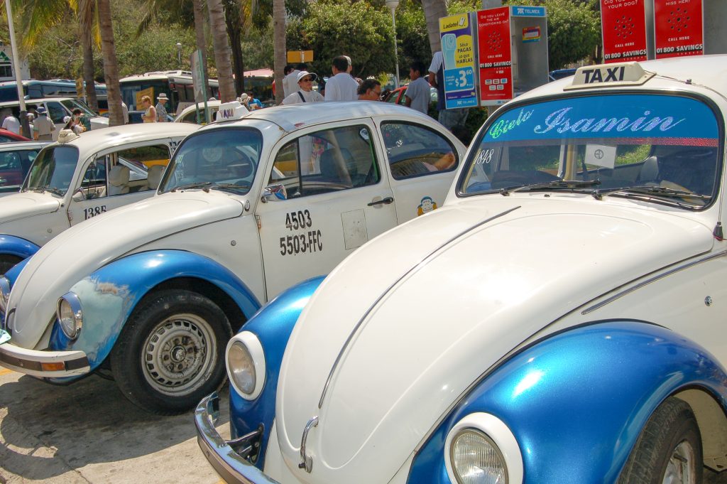 Row of 3 white VW Beetle Cars with blue wheel hubs and visas.