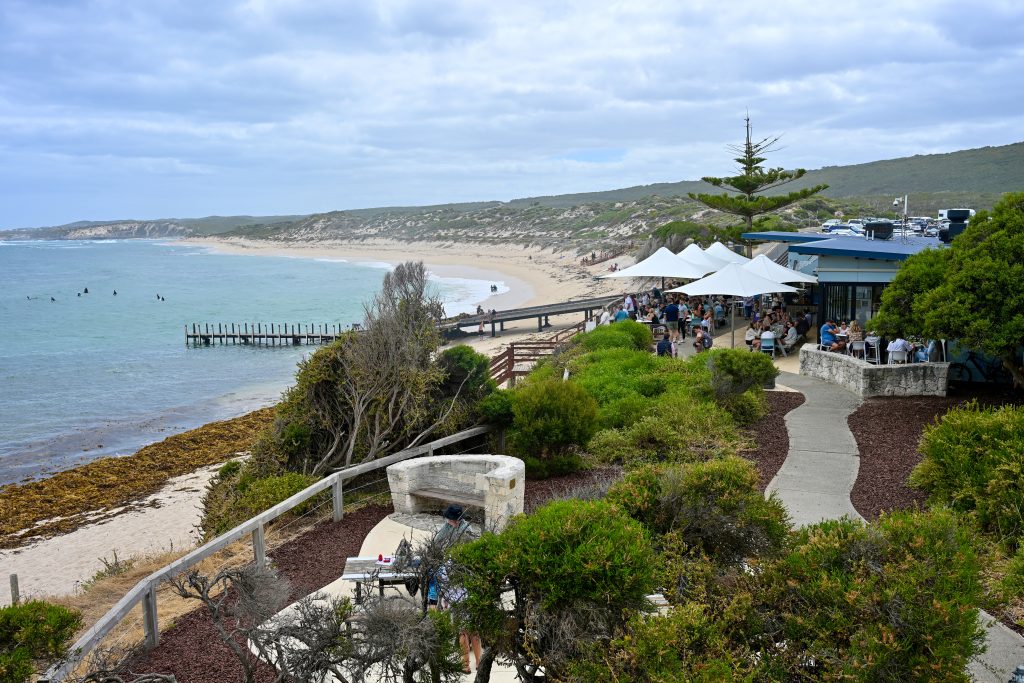 Restaurant buildings overlooking a wide beach with blue water and sky