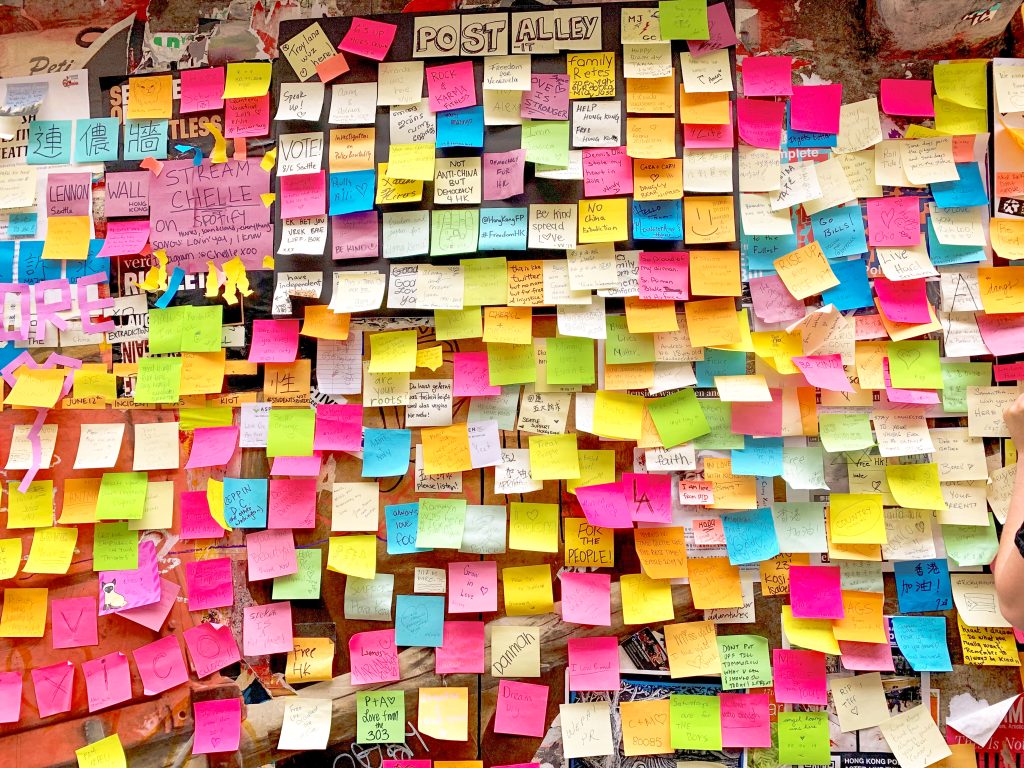 Multicoloured post-it notes with messages on wall at Post Alley