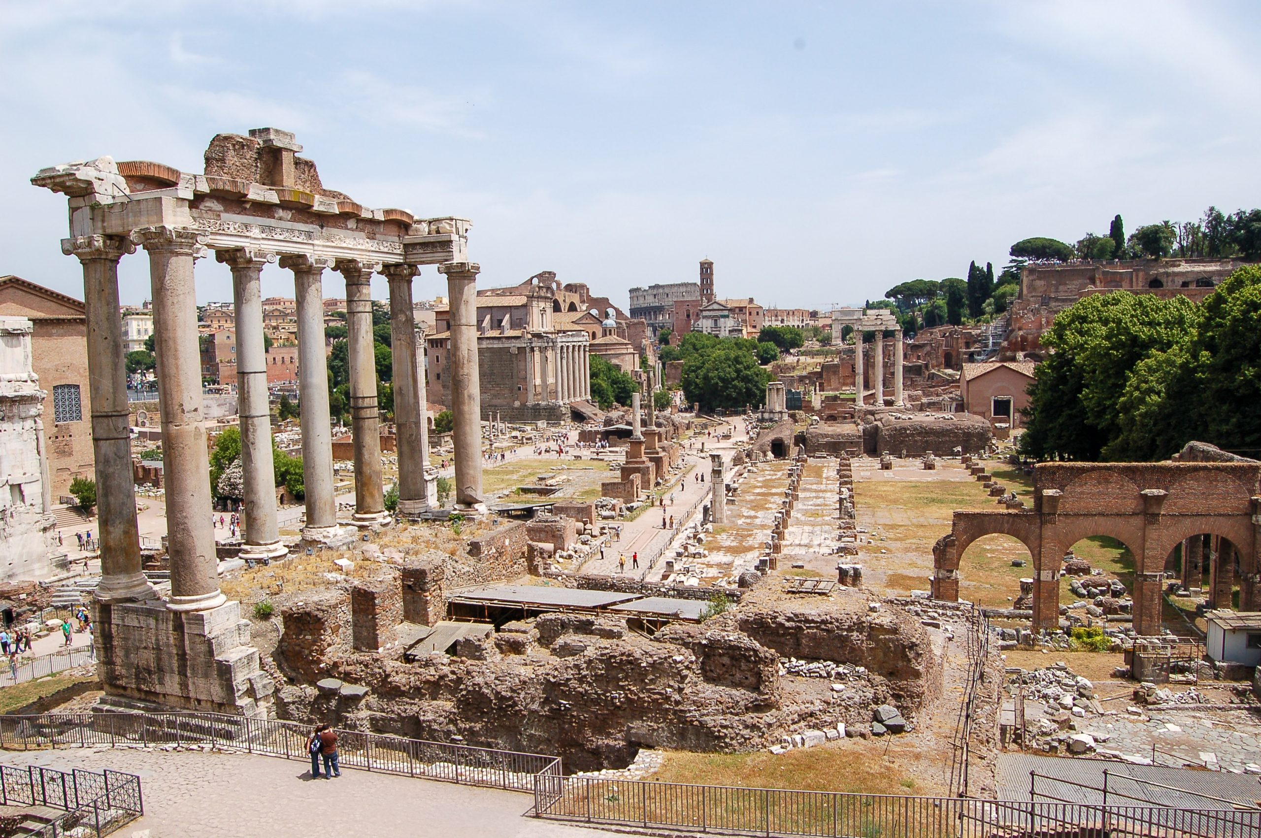 View down onto an area of ancient ruins. The tall columns of a temple stand to the left hand side