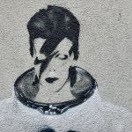 Spray painted mural / graffiti picture of David Bowie in space suit on a white wall