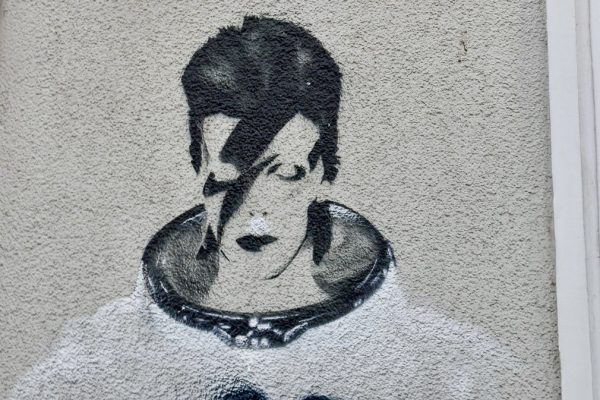 Spray painted mural / graffiti picture of David Bowie in space suit on a white wall