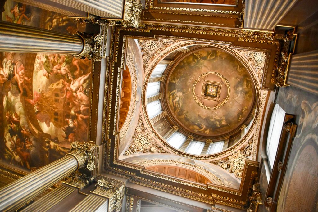 Looking up to a painted ceiling with columns to the left