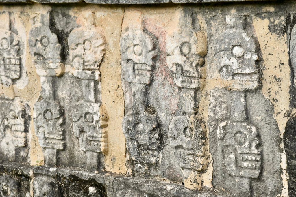 Carvings of two rows of skulls - they are not very well preserved so look very old