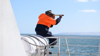 Man with spyglass solo travelling with nut allergy ferry to Kangaroo island Australia