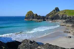 A gorgeous cove - sandy beach with rocks on the sand. Turquoise and blue sea.