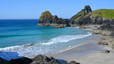 A gorgeous cove - sandy beach with rocks on the sand. Turquoise and blue sea.