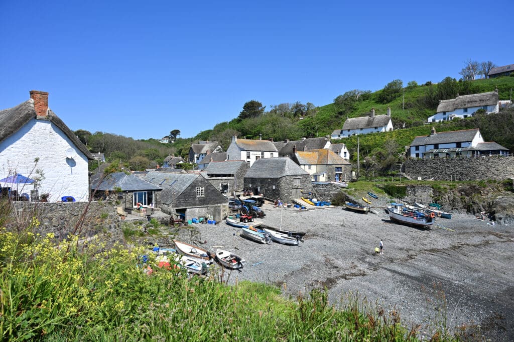 Looking down on a small harbour filled with cottages and boats under a blue sky