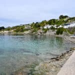 View of a small harbour village. Cluster of small cottages around a body of turquoise water.