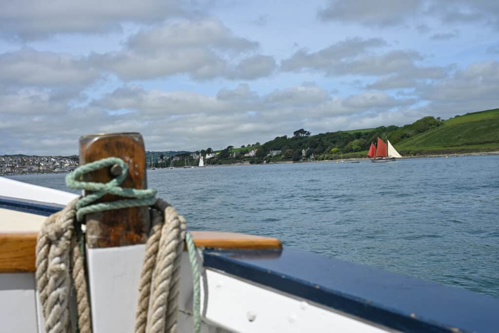 View over the side of boat across river to town and hills beyond