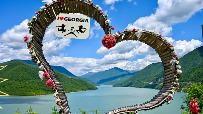View of a reservoir surrounded by hills, taken through a wooden heart.