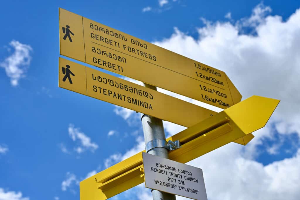 Yellow arrow signposts pointing to the Gergeti Fortress, and Stepantsminda.