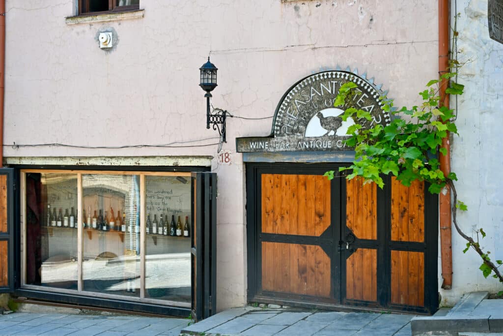 The entrance to a Wine Bar called Pheasant's Tears - wooden stable doors to the right and window display of the wine to the left.