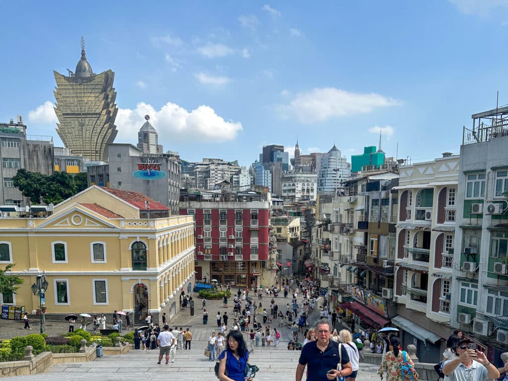 Looking down staircase to street below and a tall glass lotus shaped building to the left