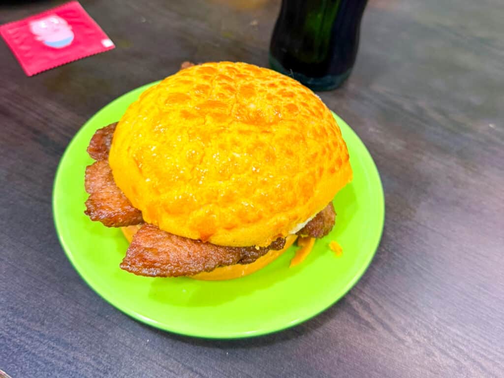 BUrger bun with meat on a green plate