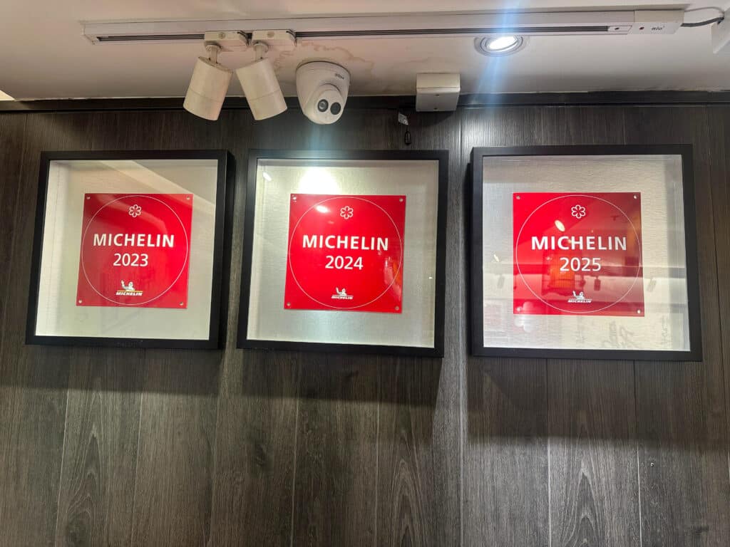 Three framed red Michelin guide pictures for 2023, 2024, 2025
