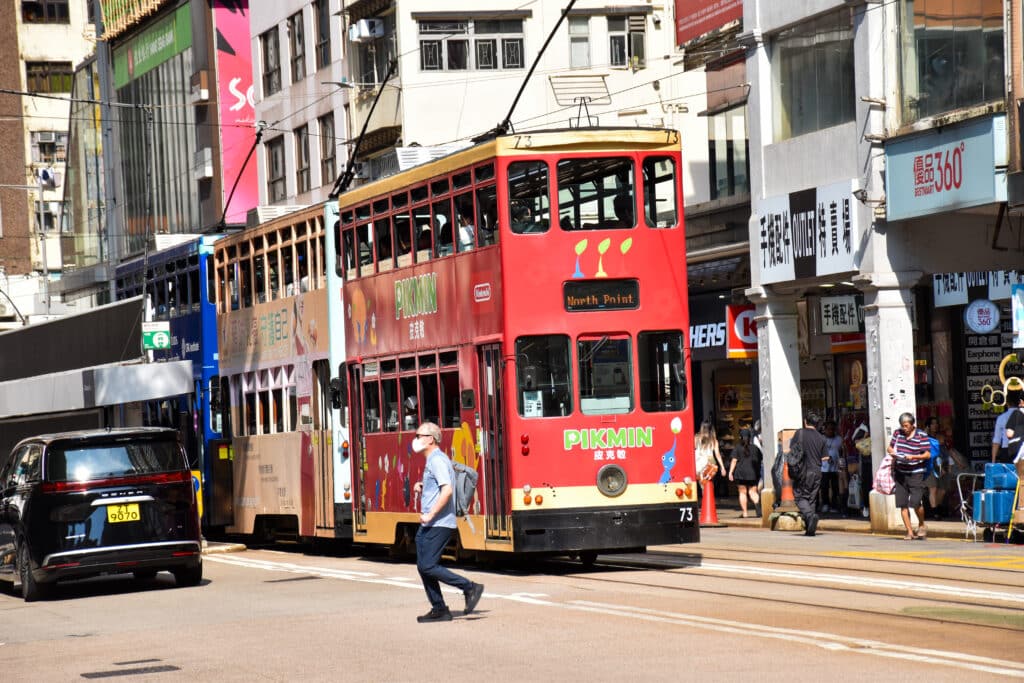 A thin red double decker tram