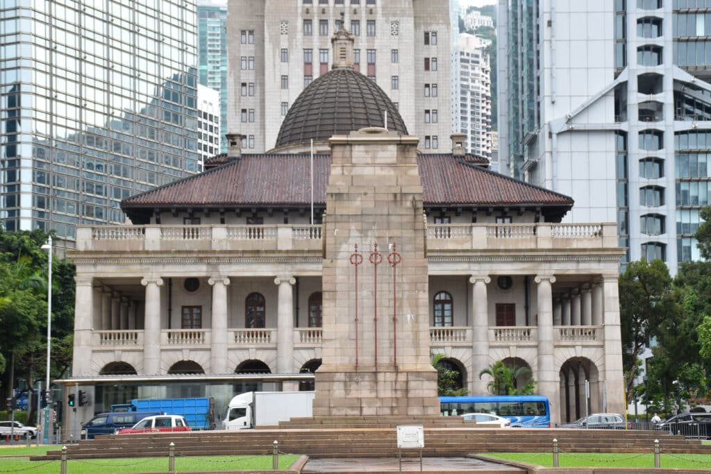 An old Colonial style building in front of modern office blocks