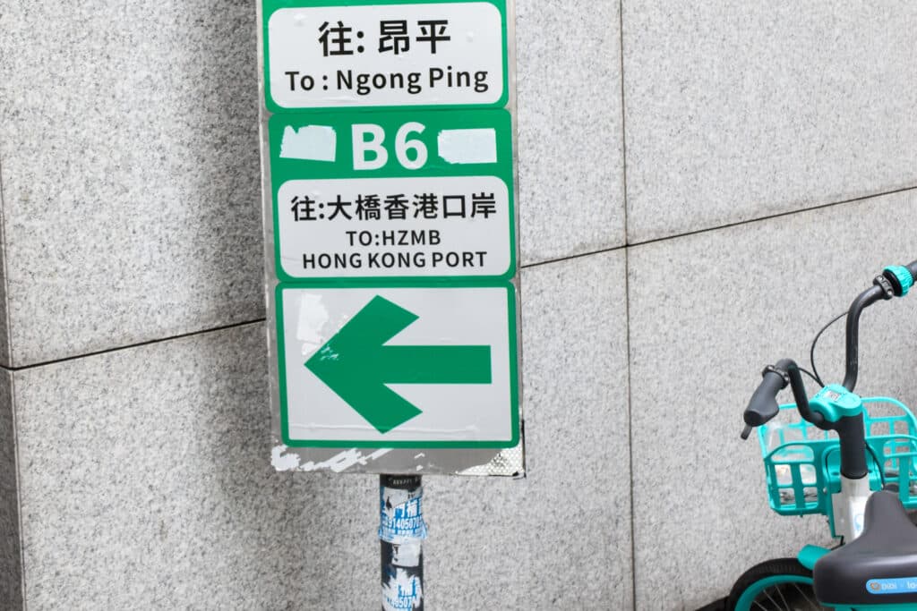 Sign to Ngong Ping and Hồng Kông Port. White ơn green