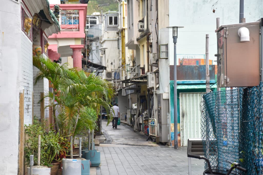 Man walking away from camera down a narrow street. old buildings