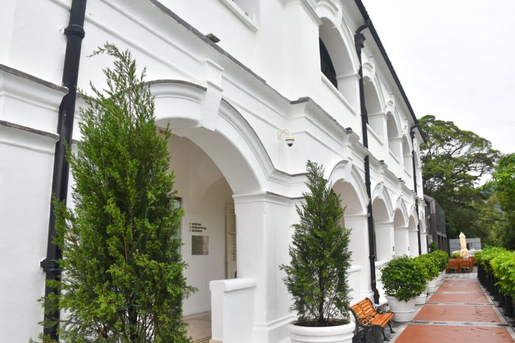 White colonial building with arches across frame