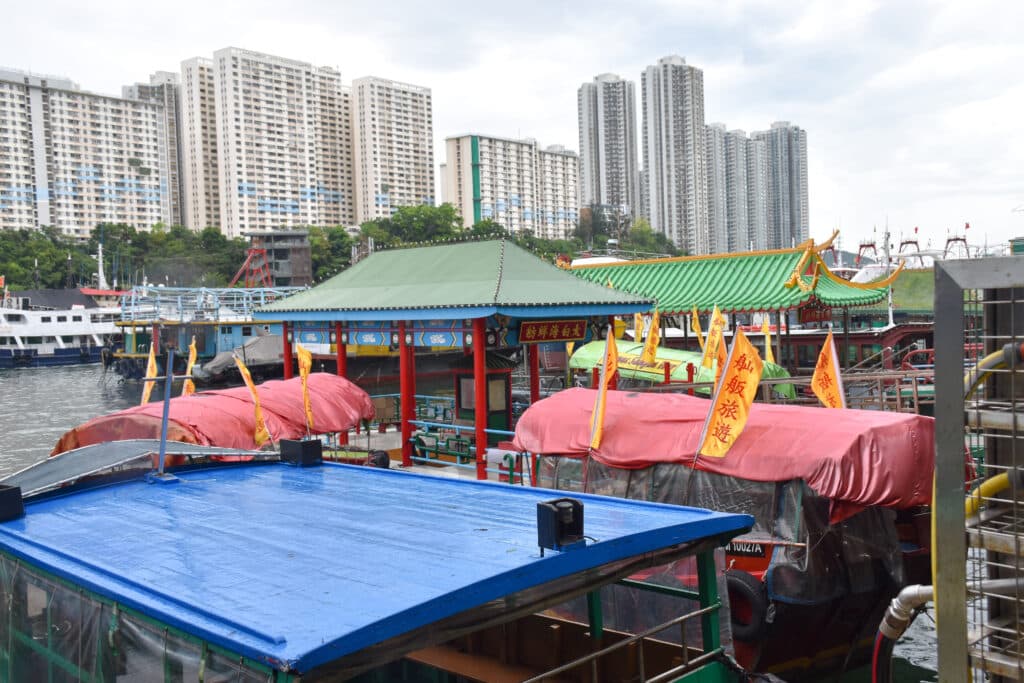 Looking over boats and floating pontoons to blocks of flats across river