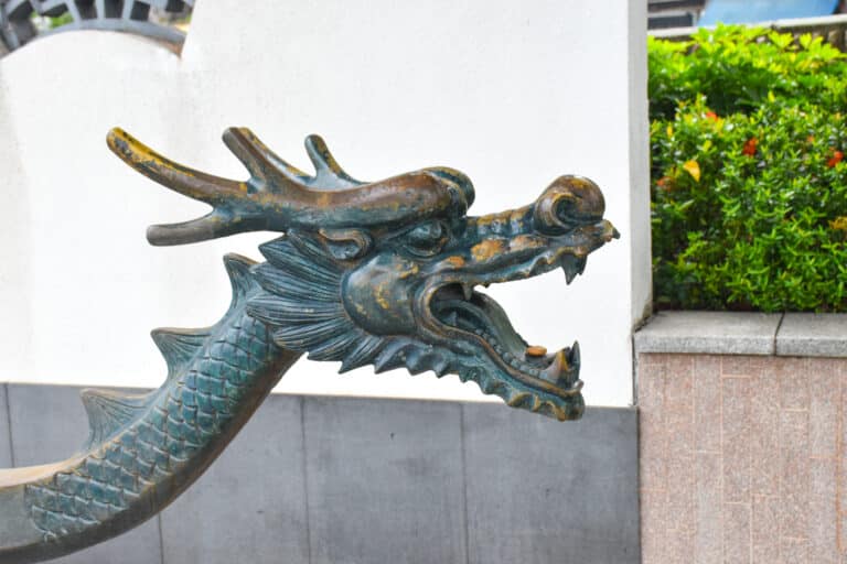 A metal dragon head with mouth open faces to the right