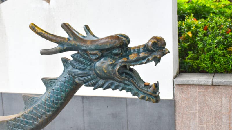 A metal dragon head with mouth open faces to the right