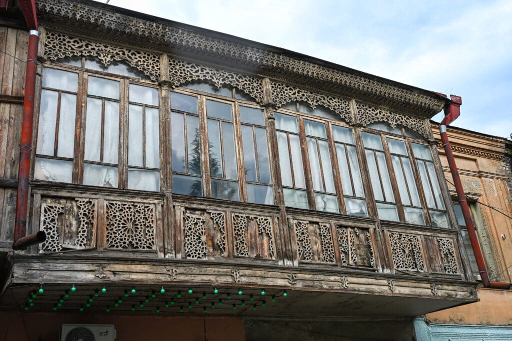 Ornately carved large wooden balcony with glass windows