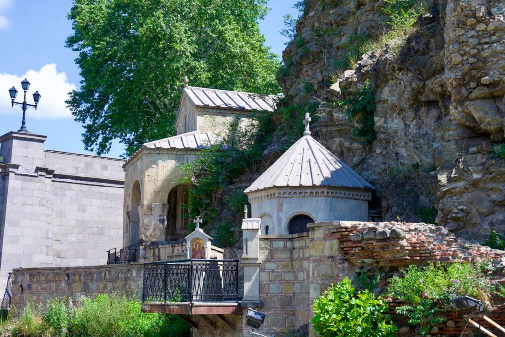 Cluster of small stone church buildings in front of stone wall