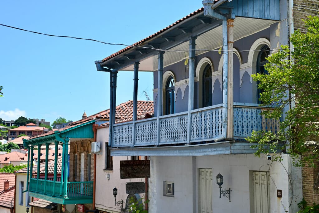 Old painted wooden balconies (green and blue) outside houses