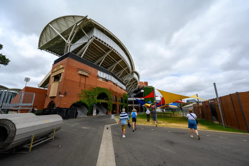 Adelaide Oval Tour visitors walking past brick stands and shade sails