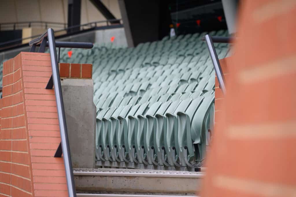 Adelaide Oval Tour rows of green stadium seats between brick walls
