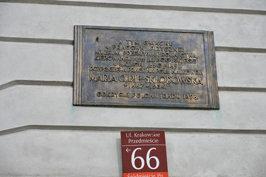 Brass plaque on wall advertises where Marie Curie lived at Number 66