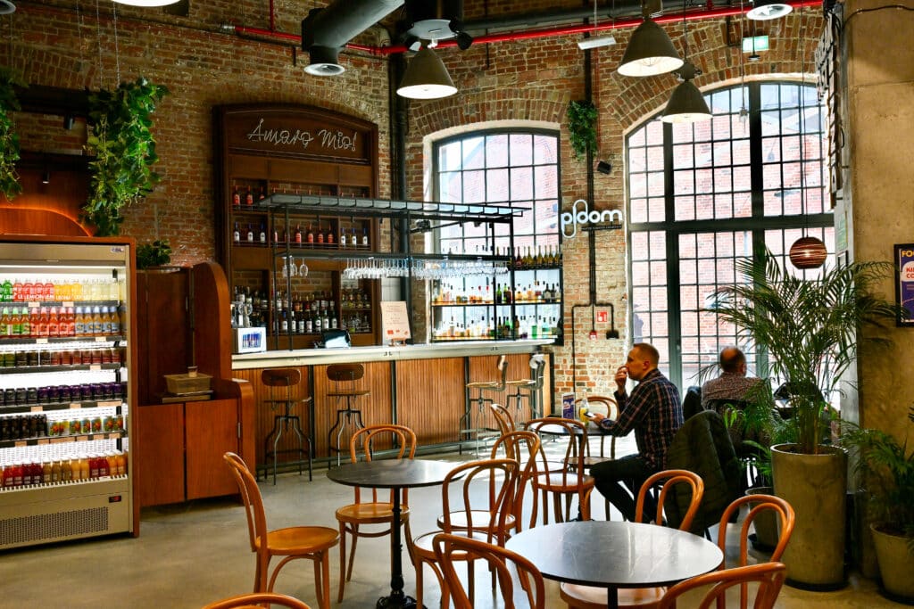 Inside an industrial building with cafe tables and bar