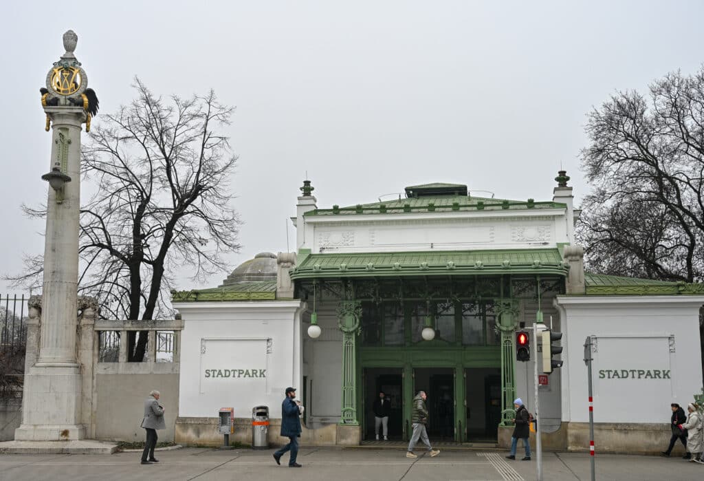 A white building with green trim advertising Stadtpark. Column to the eft.