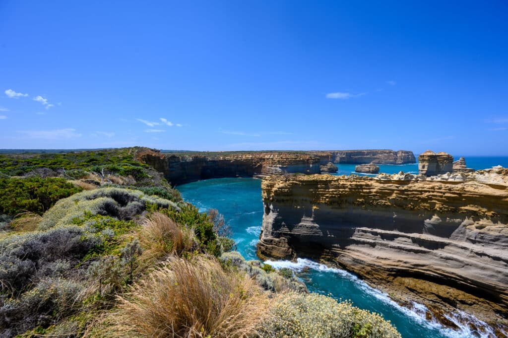 The Razorback’s long, layered limestone wall rises above a narrow ocean channel near Loch Ard Gorge in Victoria.