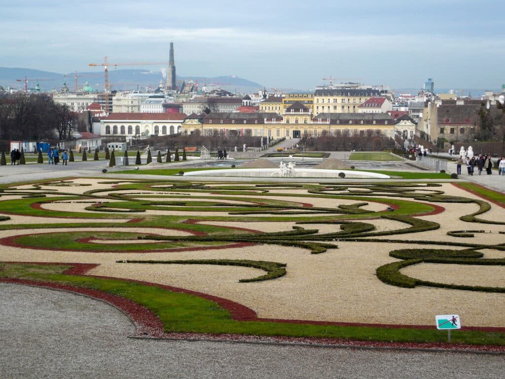 Looking down a manicured garden towards smart buildings in background
