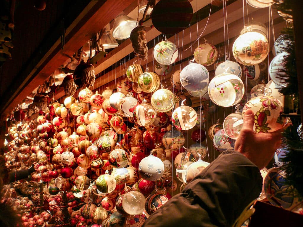 A hand reaches up to pick a bauble from a market stall of baubles