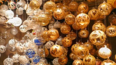 Rows of gold and silver glass baubles hang on strings across the frame