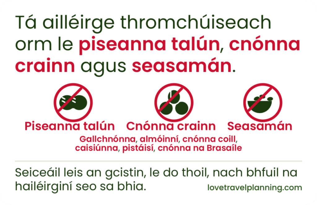 Irish-language nut allergy card stating a severe allergy to peanuts (piseanna talún), tree nuts (cnónna crainn) and sesame (seasamán), with three crossed-out icons and a kitchen check request.