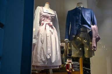 Shop window featuring traditional German or Austrian outfits - one woman and one male