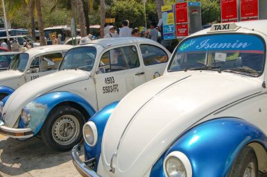 Row of 3 white VW Beetle Cars with blue wheel hubs and visas.